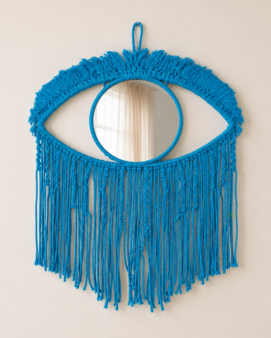 Blue fringed mirror on a beige wall