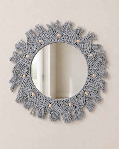 Round mirror with macrame frame on a beige wall