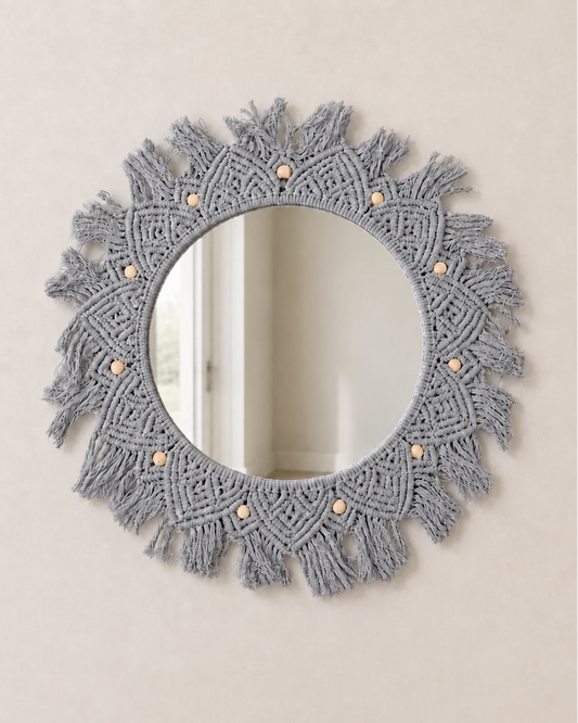 Round mirror with macrame frame on a beige wall