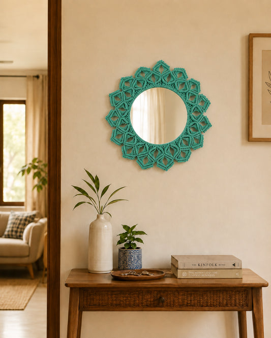 Decorative teal mirror on a wall above a wooden console table with books and plants.
